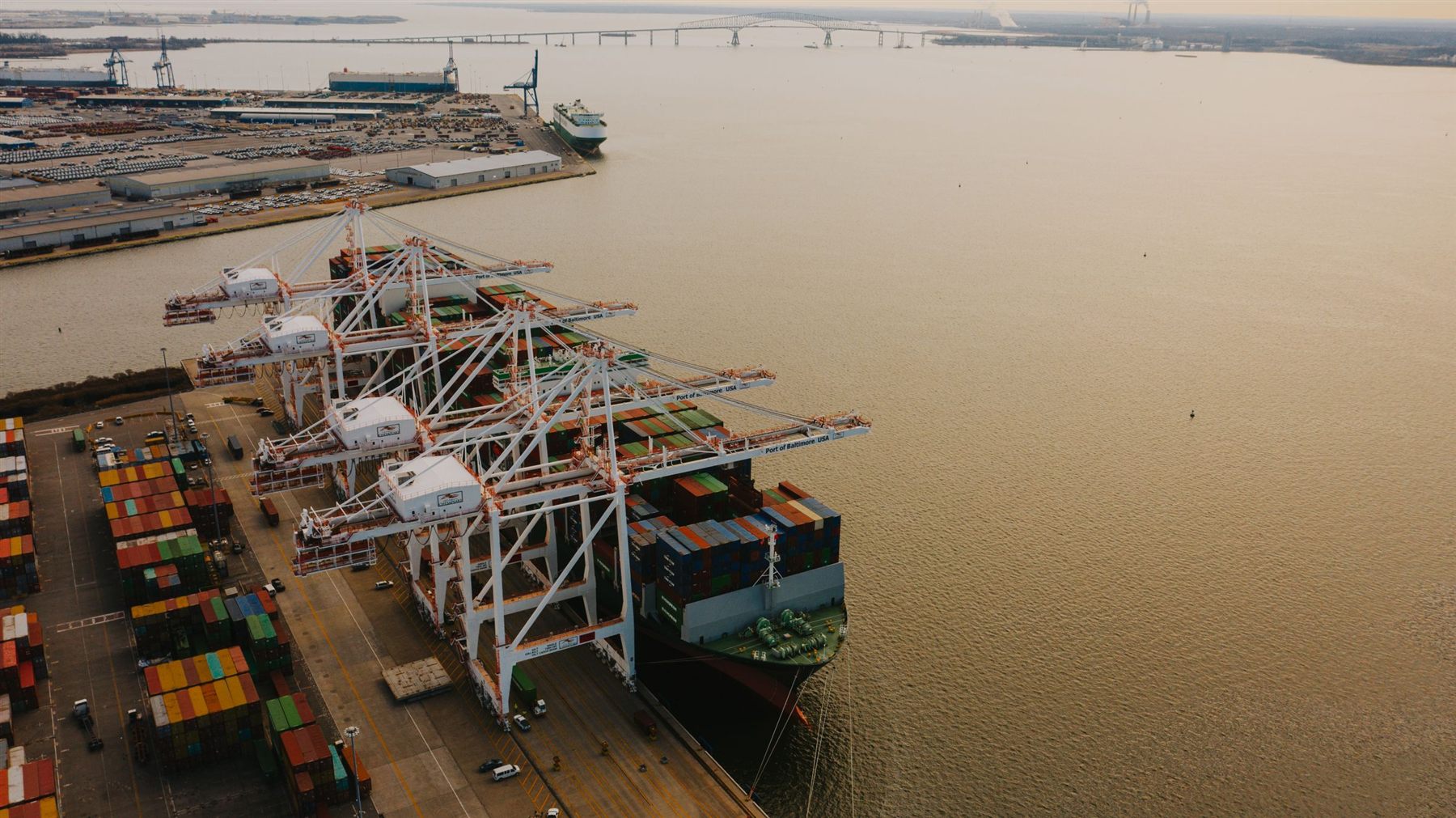 Cranes loading a cargo vessel with shipping containers