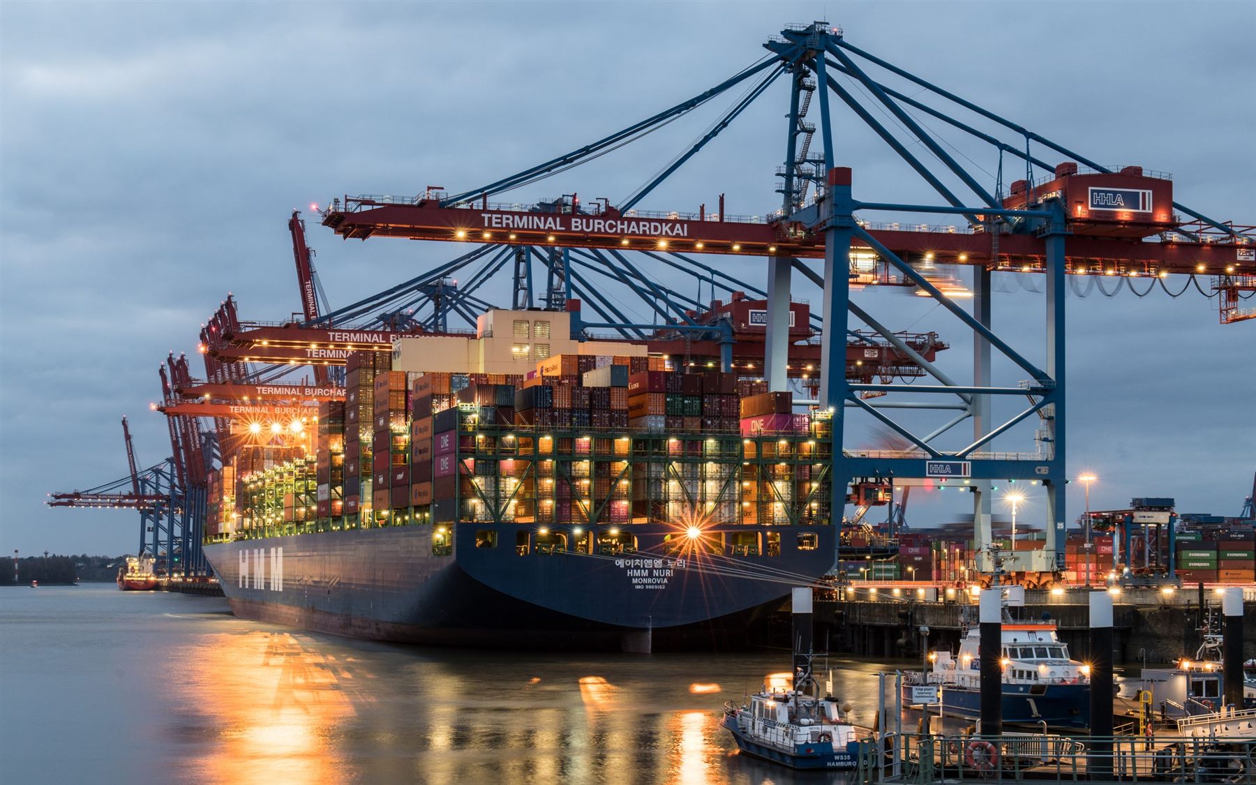 Container terminal with cranes and ships at night