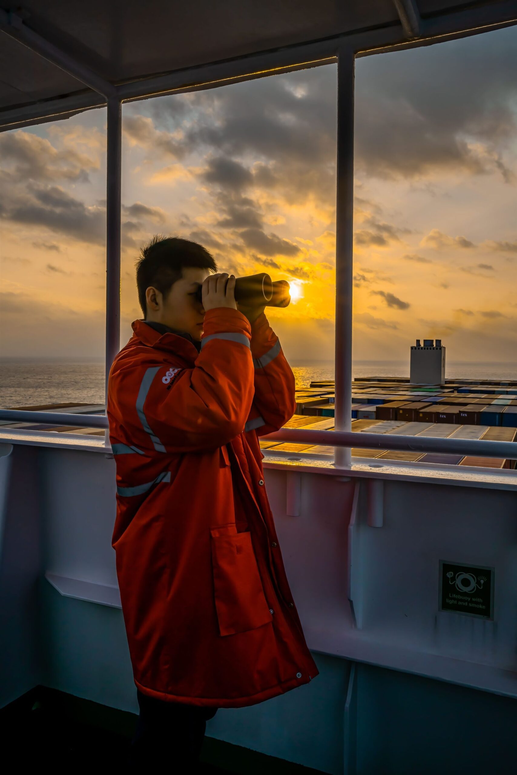 Crew member on a container ship at sunset